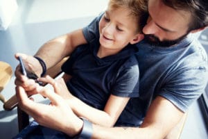 Far har sønn på fanget mens de ser på telefonen sammen