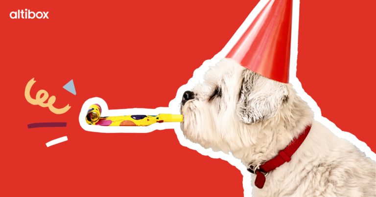 Hund med rød partyhatt blåser konfetti