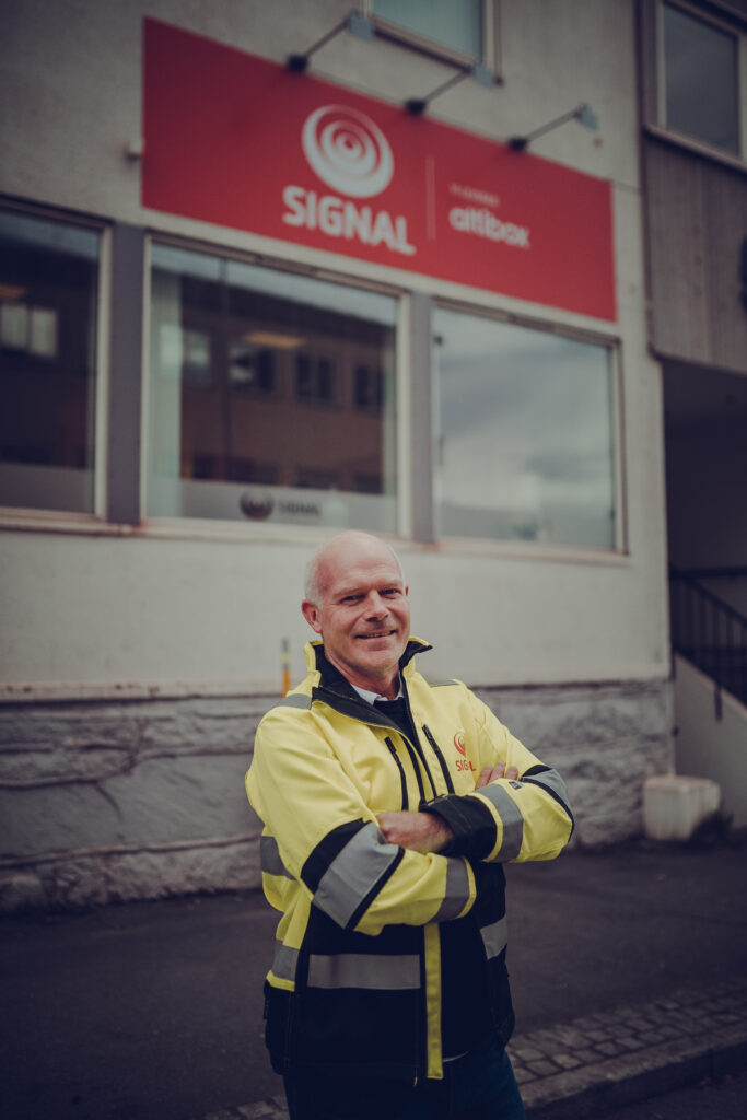Kåre Berglund står i arbeidsjakka foran Signal-kontoret i Narvik