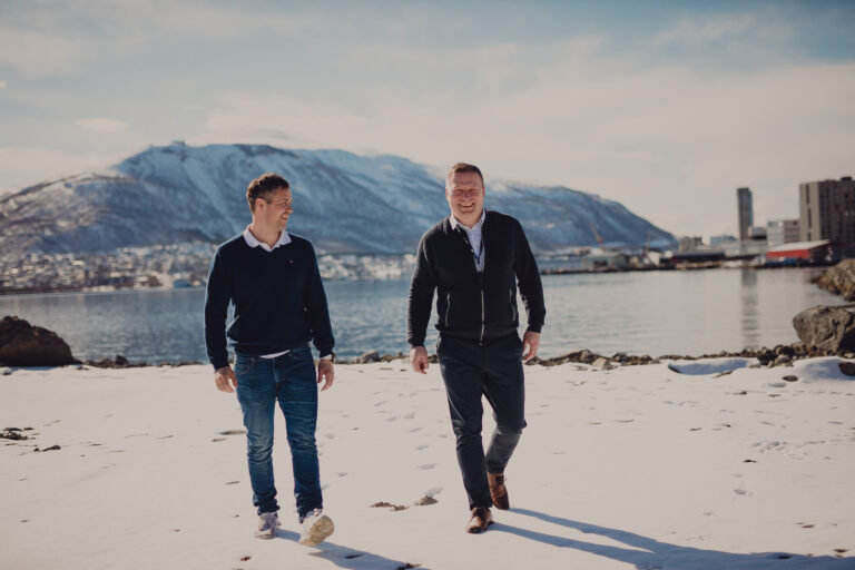 To av Signals ansatte som går på en strand i Tromsø