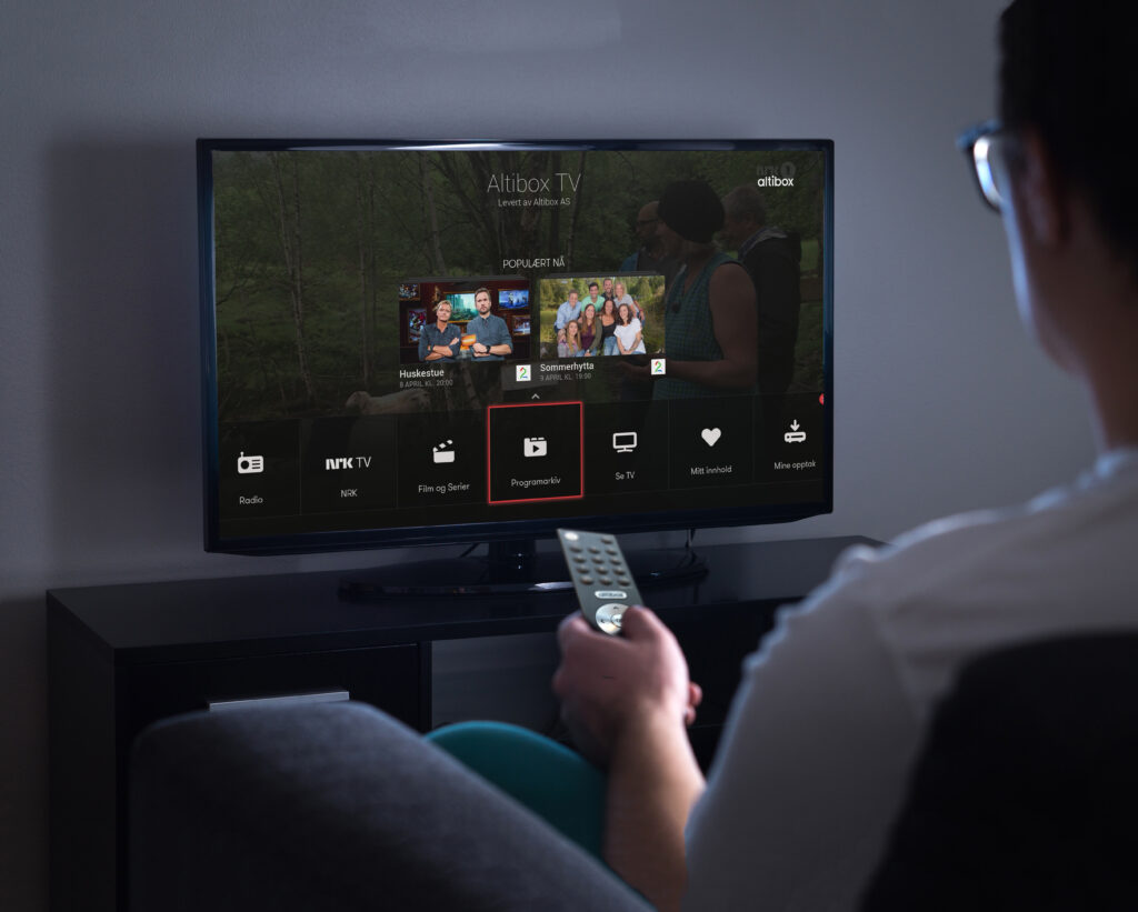 Man watching tv or streaming movie or series with smart tv at home. Film or show on television screen. Person holding the remote control or switching channel. Turning on or off tv.